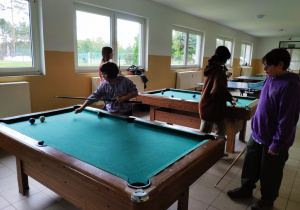 Uczniowie grający w bilarda.